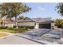 Charming home with a contemporary driveway design featuring grass accents and a spacious two-car garage at 7108 Pelican Island Dr, Tampa, FL 33634