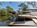 Image features a boat on a boat lift on the water, with a dock and trees surrounding the area at 733 Captiva Ne Ct, St Petersburg, FL 33702