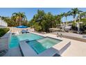 Backyard features a beautiful pool with a jacuzzi and poolside lounge chairs under a blue umbrella at 733 Captiva Ne Ct, St Petersburg, FL 33702