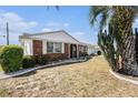 A well-maintained single-story brick home with mature landscaping and manicured lawn at 832 Fox Hills Dr, Sun City Center, FL 33573