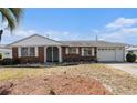 Charming single-story brick home featuring a well-maintained lawn and an attached garage at 832 Fox Hills Dr, Sun City Center, FL 33573
