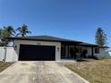 Charming single-story home featuring a modern black garage door and a well-manicured lawn at 926 Eagle Ln, Apollo Beach, FL 33572