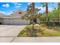 Charming home featuring a three-car garage, manicured landscaping, and a picturesque setting during the day at 10511 Mistflower Ln, Tampa, FL 33647