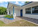 Inviting front porch with tile flooring, blue accents, and landscaping adding to the home's charm at 1099 7Th Ne Ave, Largo, FL 33770