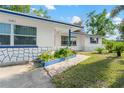 Home with blue accents, stone veneer, and charming landscaping enhancing its street appeal at 1099 7Th Ne Ave, Largo, FL 33770
