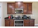 Well-equipped kitchen features a stainless steel microwave and range, with dark cabinets and granite counters at 11504 Harlan Eddy Ct, Riverview, FL 33579