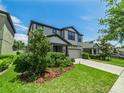 Attractive two-story home featuring a well-kept lawn, mature trees, and a two-car garage at 1220 Florablu Dr, Seffner, FL 33584