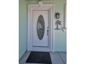 Close-up of the elegant front door with decorative glass and detailed trim, accented by a welcome sign at 14984 Cromwell Dr, Clearwater, FL 33764