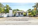 Charming white home featuring a cozy entryway, palm trees, and a striking chimney design at 1702 E Knollwood St, Tampa, FL 33610