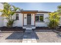 Curb view of single Gathering residence with a dark front door and well-kept landscaping at 1702 E Knollwood St, Tampa, FL 33610