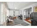 Bright sunroom with desk space, large windows, and a view into the living area with hardwood floors at 2235 Burlington N Ave, St Petersburg, FL 33713