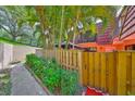 View of a two-story townhome with a patio, gazebo, balcony, and tropical landscaping at 2627 2Nd Ct, Palm Harbor, FL 34684