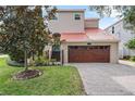 Home with a two-car garage, red tile roof, and brick paved driveway at 2701 W Bay Ave, Tampa, FL 33611