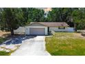 Well-kept single-story home with an attached garage, surrounded by mature trees and a fenced in yard at 3728 Parkway Blvd, Land O Lakes, FL 34639