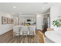 Open-concept kitchen featuring gray cabinetry, stainless steel appliances, an island, and wood flooring at 5133 Harbinger Rd, Spring Hill, FL 34608