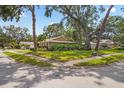 Corner lot property with a well-maintained lawn, mature trees, and attractive landscaping at 5600 Bay Pines Lakes Blvd, St Petersburg, FL 33708