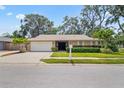 Beautiful home featuring a well-kept lawn, tasteful landscaping, and a convenient two-car garage at 5600 Bay Pines Lakes Blvd, St Petersburg, FL 33708