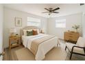 Serene bedroom with neutral tones, plush bedding, ceiling fan and natural light; designed for relaxation at 5911 63Rd N Ter, Pinellas Park, FL 33781