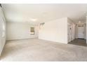 Spacious living room with light-colored walls and carpet flooring, naturally lit by a window at 6967 Silverado Ranch Blvd, Zephyrhills, FL 33541