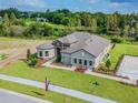 A stunning aerial view of a single Gathering house, showcasing landscaping, pond, and parking spaces at 712 Estates Blvd, Tarpon Springs, FL 34689