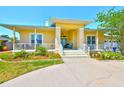 Charming home with a welcoming front porch, well-manicured lawn, colorful plants, and an inviting entrance at 732 Kingston Ct, Apollo Beach, FL 33572