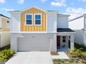 Two-story home with an attached garage, neutral colors and a well-maintained lawn at 7797 Peace Lily Ave, Wesley Chapel, FL 33545