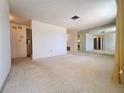 Bright living room featuring neutral carpet and a mirrored wall at 7812 Heather St, New Port Richey, FL 34653