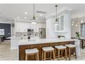 Modern kitchen with a large island, white cabinets, stainless steel appliances, and stylish pendant lights at 8518 Tidal Bay Ln, Tampa, FL 33635