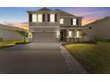 Charming two-story home with a two-car garage, landscaping, and a beautifully lit exterior at 8607 Bower Bass Cir, Wesley Chapel, FL 33545