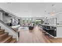 Open-concept living room with modern decor, sleek furniture, and a staircase at 8607 Bower Bass Cir, Wesley Chapel, FL 33545
