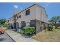 Angle shot of two-story townhouse showcasing siding and brick accents with walkway at 9031 Westchester Cir # 128, Tampa, FL 33604