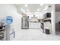Bright kitchen with marble floors, stainless steel refrigerator, and white cabinetry at 9031 Westchester Cir # 128, Tampa, FL 33604