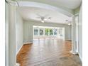 Expansive living area with hardwood floors, columns, and large windows offering water views at 9265 Treasure Ln Ne, St Petersburg, FL 33702