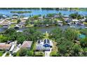 Panoramic aerial view of a home, showcasing solar panels and its prime waterfront location with lush landscaping at 9303 Alice Ln, Riverview, FL 33578