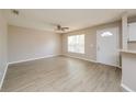 Bright living room with modern ceiling fan, light wood-look flooring, neutral walls, and natural light from the window at 10112 N Mitchell Ave, Tampa, FL 33612