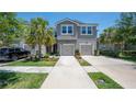 Charming townhome with a two-car garage, palm trees, and well-maintained landscaping at 10127 Newel Valley Loop, Riverview, FL 33569