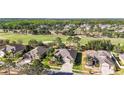 Aerial view showcasing a neighborhood with well-maintained homes, lush landscaping, and scenic views of the golf course at 10517 Palm Cove Ave, Tampa, FL 33647