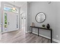 Bright entryway with sleek gray flooring, a console table with a mirror, and a front door with transom windows at 10517 Palm Cove Ave, Tampa, FL 33647