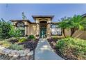 Close-up of home's front entrance with manicured landscaping and a walkway to the door at 12923 Colony Rd, Hudson, FL 34669