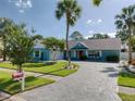 Well-maintained home with a circular paver driveway, lush lawn, and mature palm trees for a tropical feel at 16605 Round Oak Dr, Tampa, FL 33618