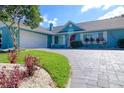 Beautiful home featuring a manicured lawn, paver driveway, and vibrant landscaping for a welcoming entrance at 16605 Round Oak Dr, Tampa, FL 33618