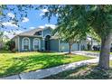 Well-maintained single-story home with a tidy lawn, mature trees, and a two-car garage at 1755 Open Field Loop, Brandon, FL 33510