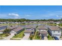 Aerial view of a well-maintained community with a scenic lake and fountain at 21003 Monza Loop, Land O Lakes, FL 34638