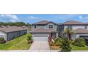 Beautiful exterior view of a two-story home, a manicured lawn, and a two-car garage at 21003 Monza Loop, Land O Lakes, FL 34638
