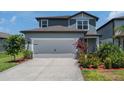 Charming two-story home featuring an attached two car garage and beautiful landscaping at 21003 Monza Loop, Land O Lakes, FL 34638