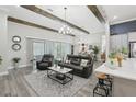Open-concept living room featuring wood-look floors, exposed beams, and modern furniture at 21746 Amelia Rose Way, Land O Lakes, FL 34637