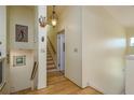 A hallway with light-yellow walls, hardwood floors, and a staircase leading to the upper level at 2202 Donato Dr, Belleair Beach, FL 33786
