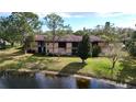 Exterior view of the condo building overlooking a grassy lawn and a pond at 2679 Sabal Springs Cir # 102, Clearwater, FL 33761