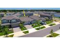 Aerial view of a modern neighborhood with a lake and well-maintained homes at 3078 Marine Grass Dr, Wimauma, FL 33598