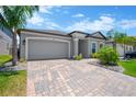 Beautiful home featuring a two-car garage and a brick paver driveway at 3078 Marine Grass Dr, Wimauma, FL 33598